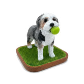 A beautiful handmade memorial sculpture of a dog with a tennis ball, created from a photo as a lasting tribute.