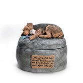 A hand-sculpted custom pet urn featuring a realistic sleeping Airedale Terrier on a grey stone-like base.