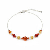 An elegant necklace or pet collar made with orange and yellow faceted crystals and a silver extender chain, displayed on a white background.