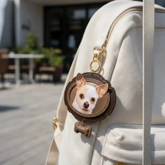 A stylish person holding a white leather handbag accessorized with a custom pet portrait leather charm, demonstrating it as a chic fashion accessory.